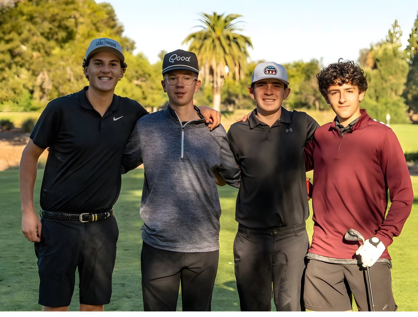 Four golfers posing together on the course