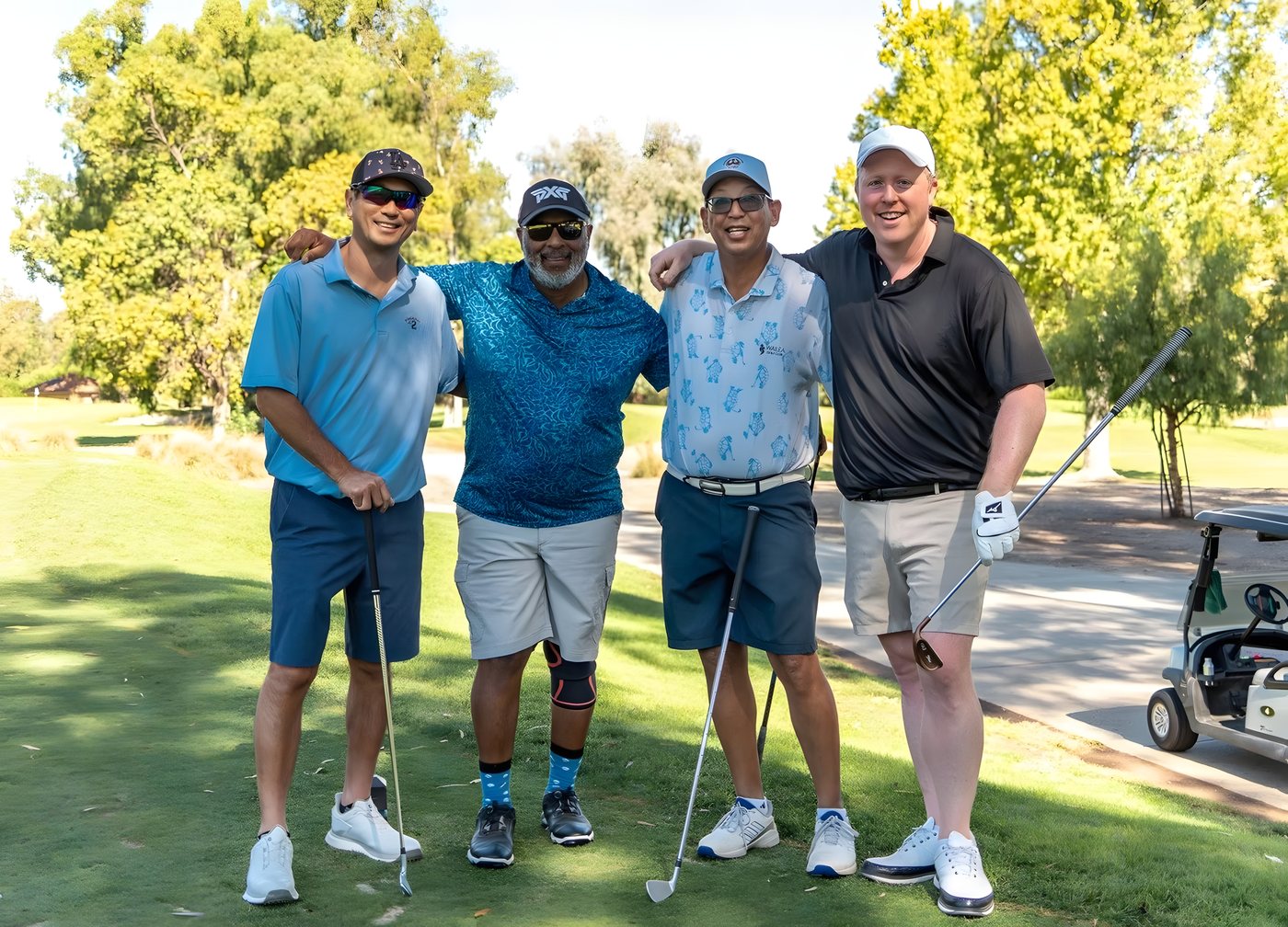 Four players posing on the fairway between holes