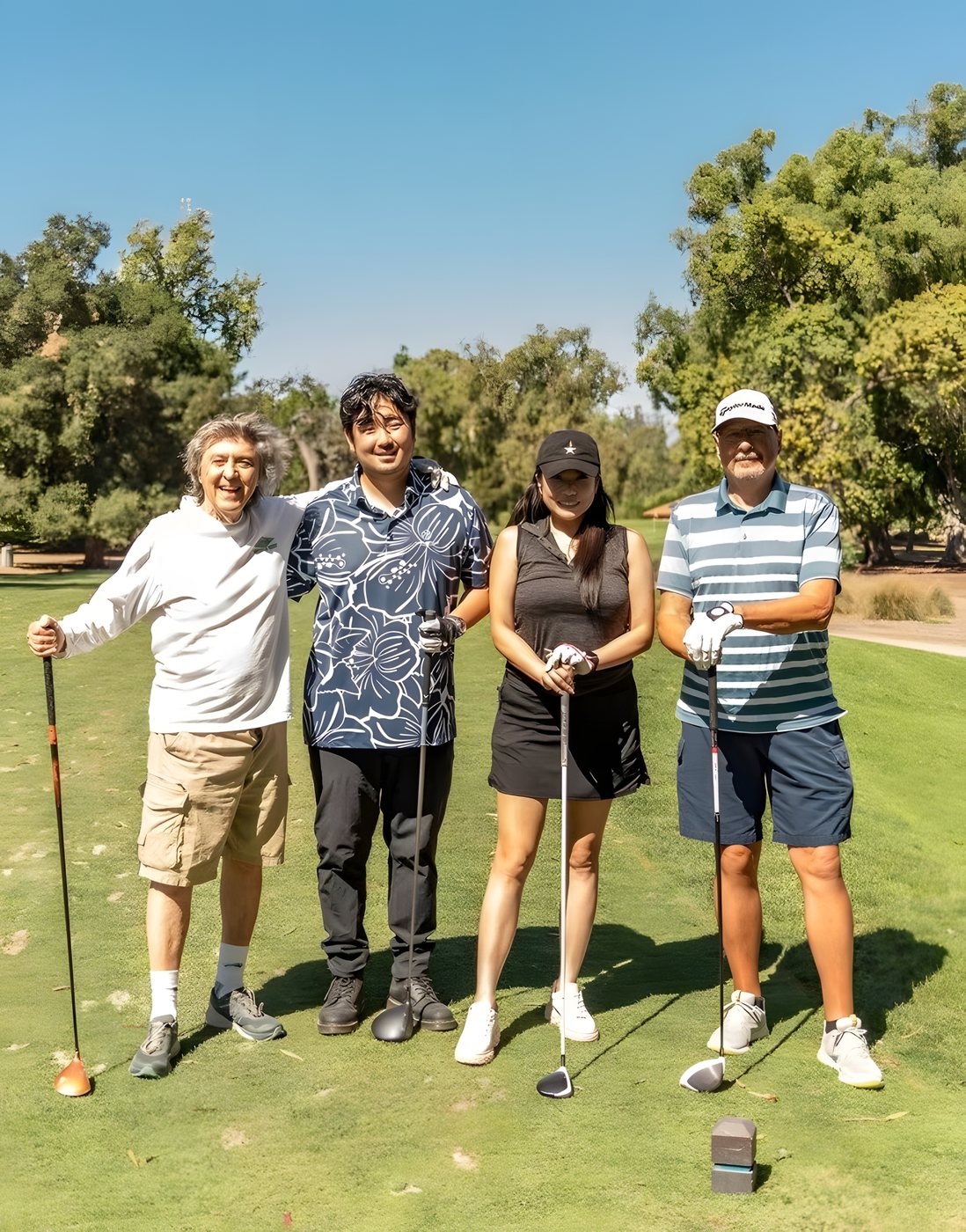 A foursome posing on the tee box before their opening shot