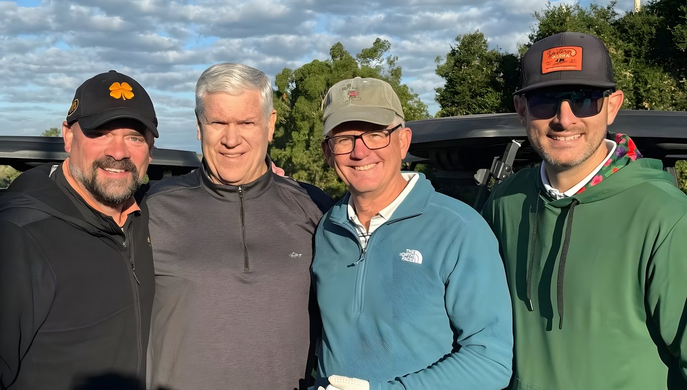 Four teammates posing on the course