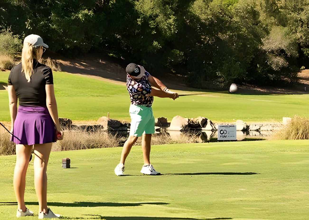 Two players on the tee, one in mid-swing