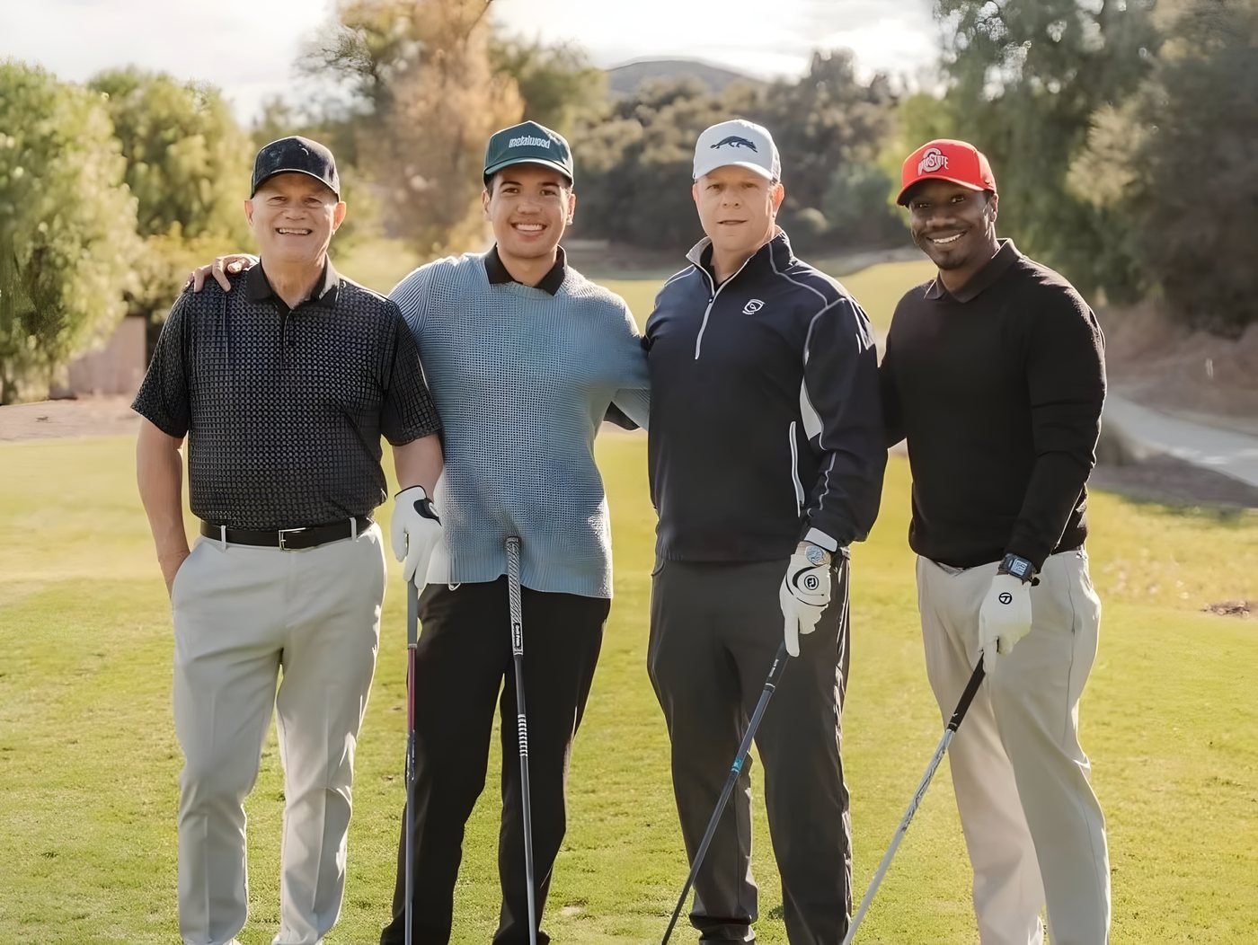 A foursome posing together on the fairway