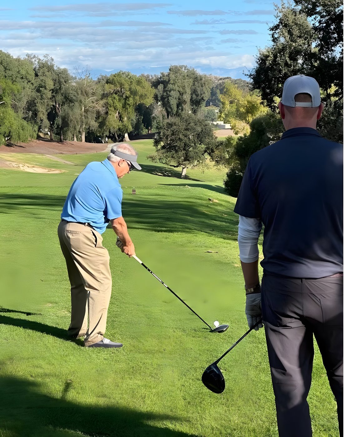 Two players on the tee box lining up their shots